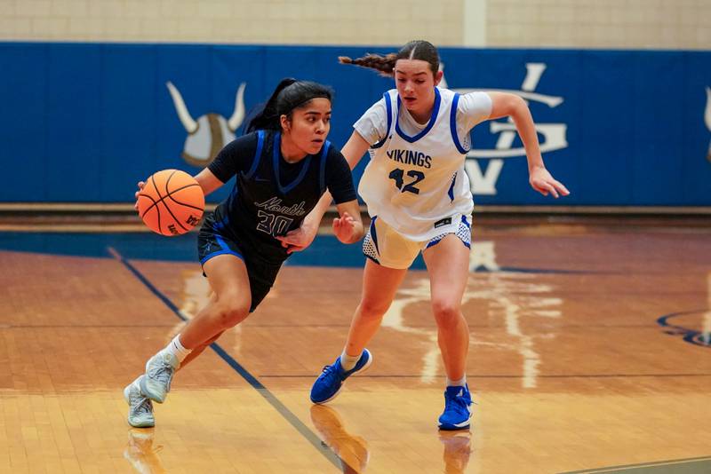 St. Charles North's Lelanie Posada (30) drives to the basket against Geneva’s Adelyn Estabrook (42) during a game at Geneva High School on Thursday, Dec. 4, 2025.
