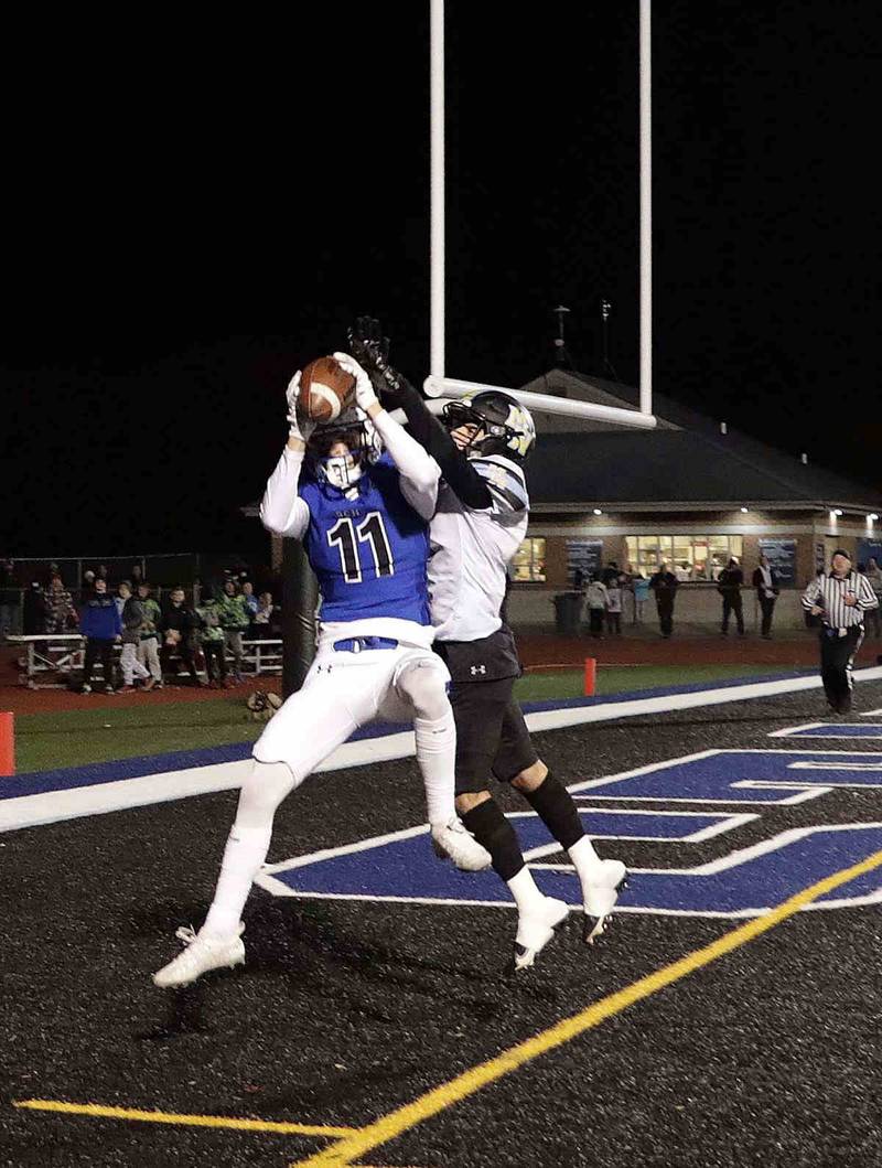 St. Charles North's Zach Priami (11) reels in a long touchdown pass over Maine West’s Adam Aboebied (5) Friday October 28, 2022 in St. Charles.