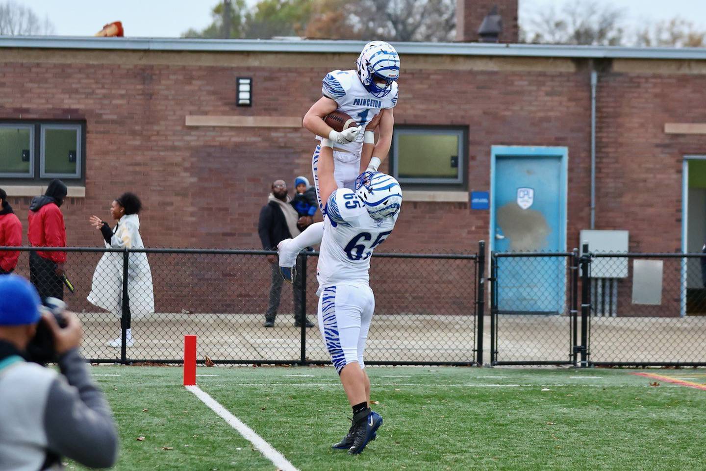Princeton's Casey Etheridge gets a lift out of  teammate Cade Odell after scoring one of his four touchdowns in Saturday's game in Chicago. The Tigers won 34-16.