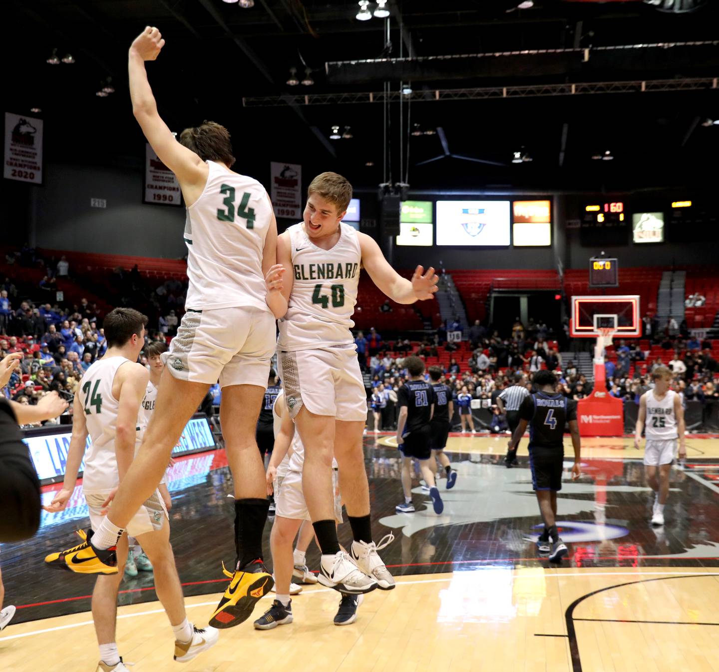 Glenbard West’s Braden Huff (34) and Jack Oberhofer (40) celebrate their Class 4A DeKalb Supersectional game win over Larkin at the Northern Illinois University Convocation Center on Monday, March 7, 2022.