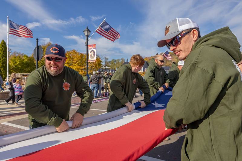 Members of Labors Local 393 roll up the large American flag after the Utica Veterans Parade and Airshow on November 2, 2025 in Utica.