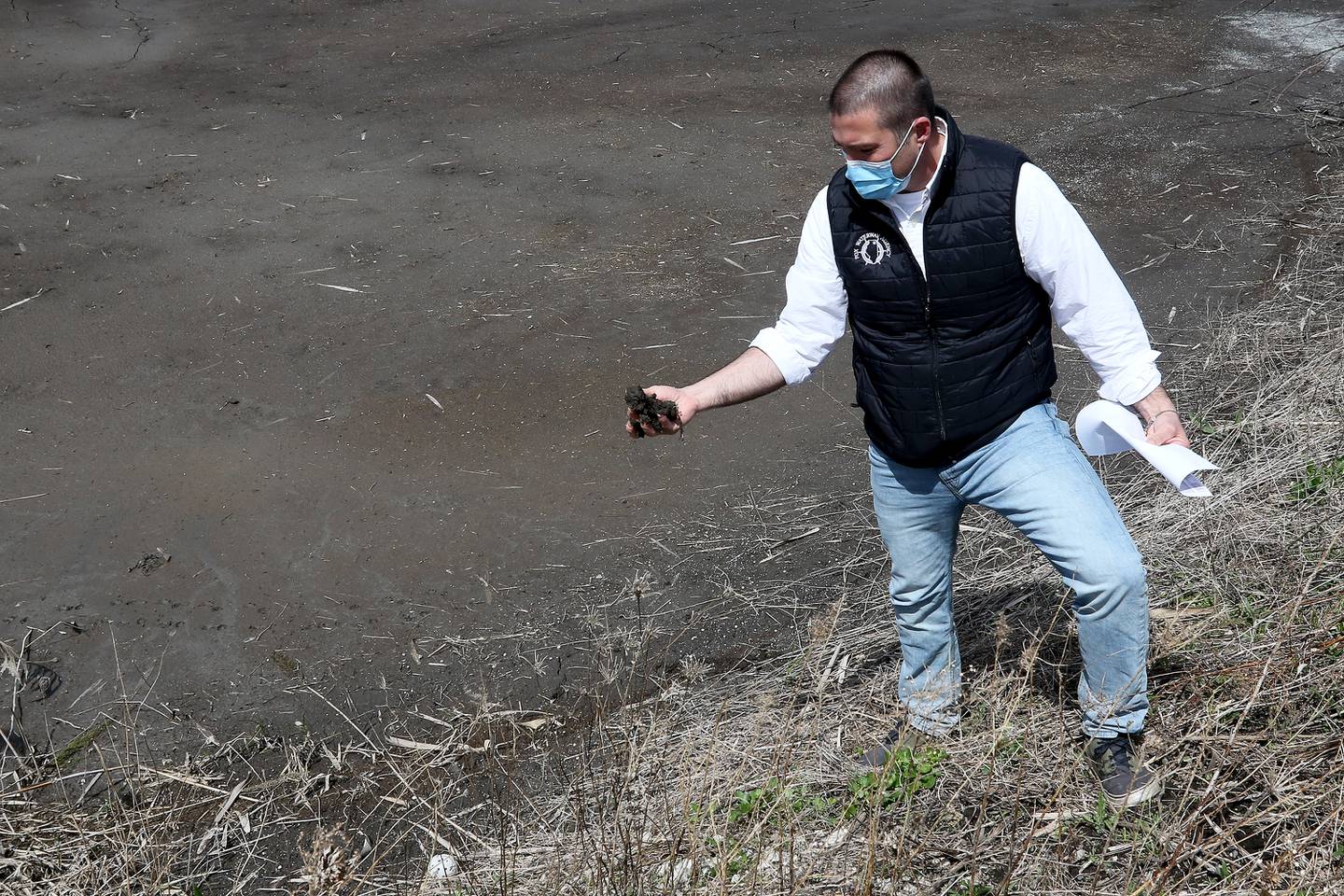 Fox Waterway Agency Executive Director Joe Keller crumbles some nutrient-rich sediment in his hands at the Cooper Farm Sediment Dewatering Facility on Tuesday, April 13, 2021, in Antioch.