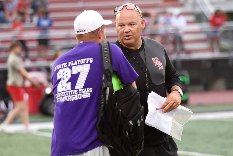 Bradley-Bourbonnais head football coach Mike Kohl, right, and Wilmington head football coach Jeff Reents shake hands at the end of the teams' joint summer workout at Bradley-Bourbonnais Wednesday, July 16, 2025.