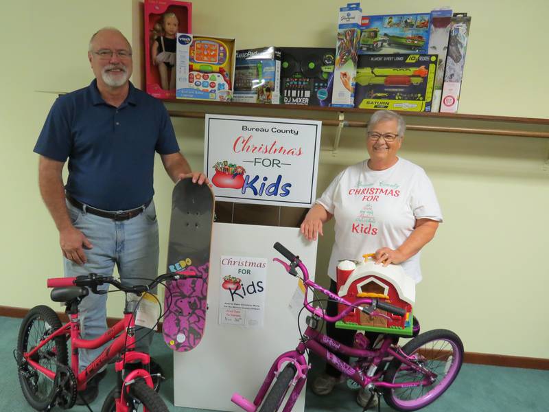 Princeton Wesleyan Church Pastor Doug Kirkpatrick (left) and Christmas For Kids Organizer Gale Hart (right) pose for a photo with donated toys for the upcoming Christmas For Kids toy drive. This year's toy campaign kicks off Nov. 1 and ends on Nov. 30.