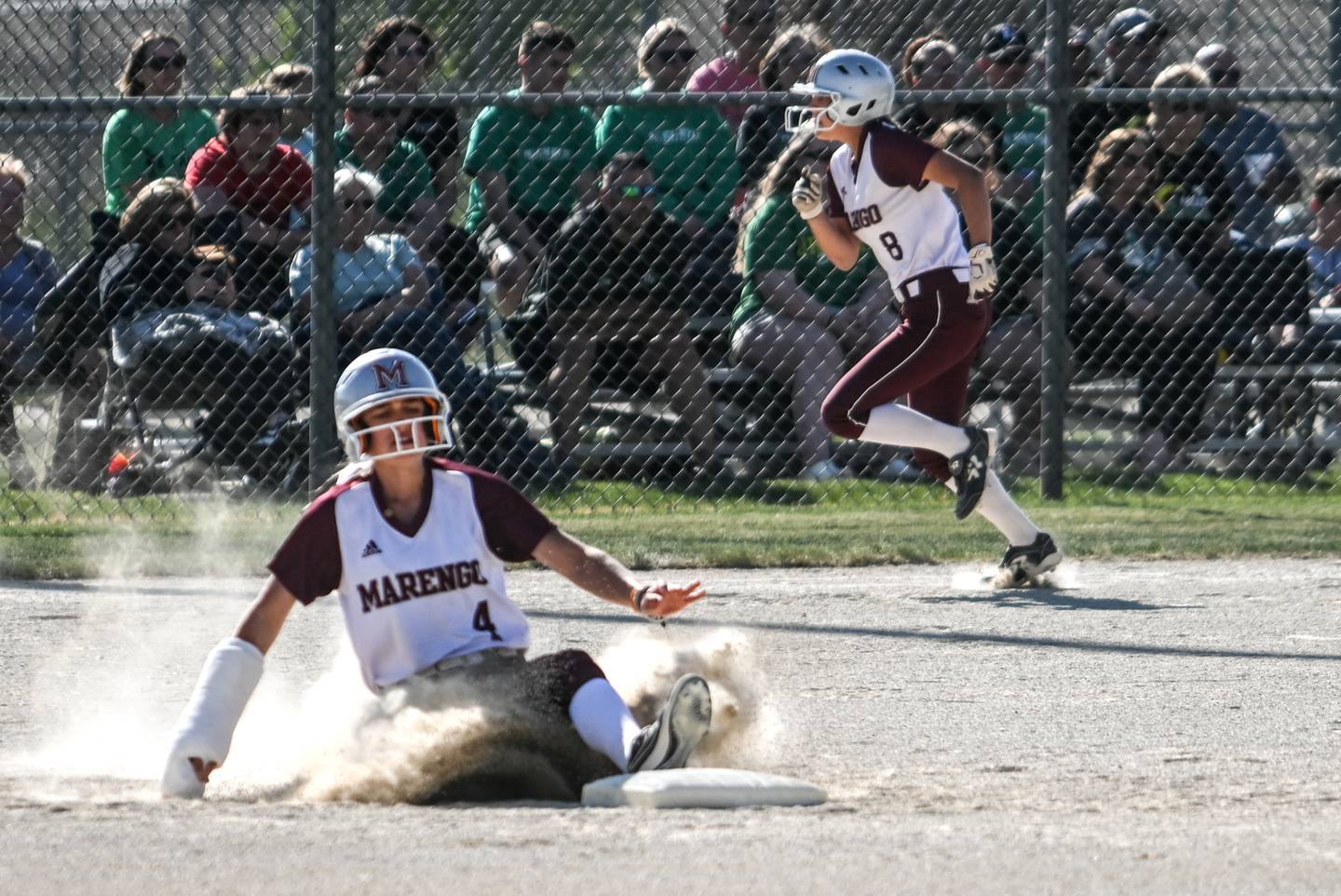 Marengo courtesy runner Maddy Christopher (4) slides safely into second on a hit and run while her teammate Gabby Gieseke tries to leg out a single during Friday's Class 2A Stillman Vaslley Sectional championship game against Rock Falls.