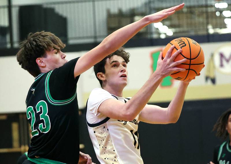 Sycamore's Jake Shipley ducks under the defense of North Boone's Michael Persson during their game Tuesday, Dec. 3, 2024, at Sycamore High School.