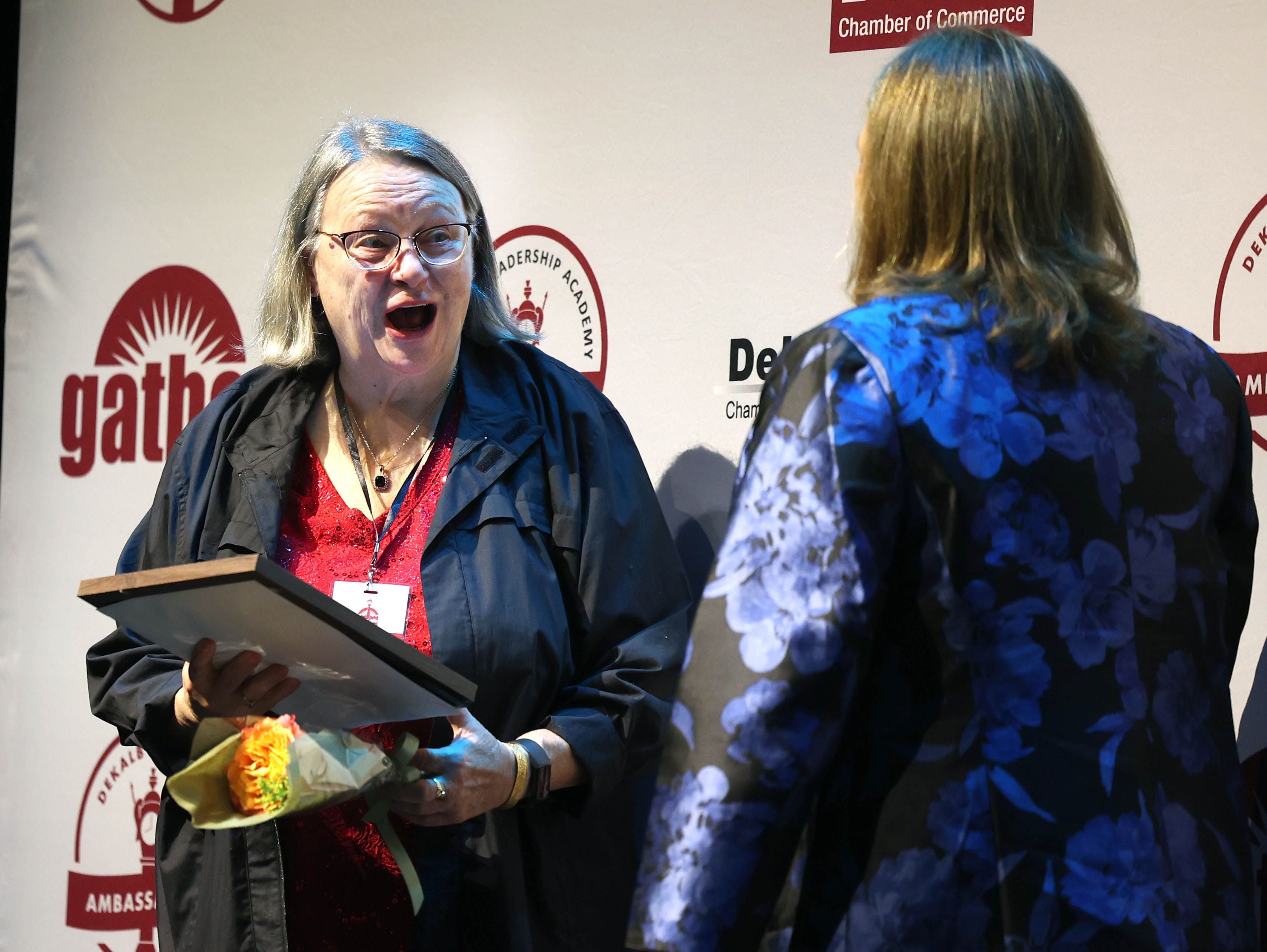 Donna Willrett (left) reacts after being presented her certificate for being a Woman of Accomplishment Honoree Thursday, Oct. 16, 2025, during the 35th annual Athena and Women of Accomplishment Award Reception at the Egyptian Theatre in DeKalb.