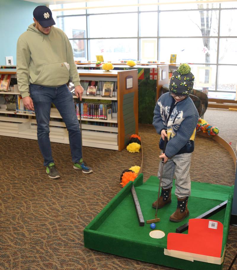 BrianZerfas watches son Colton sink a ball at the Yorkville Public Library Mini Golf FUN Raiser on Sunday, Feb. 2, 2025 in Yorkville.
