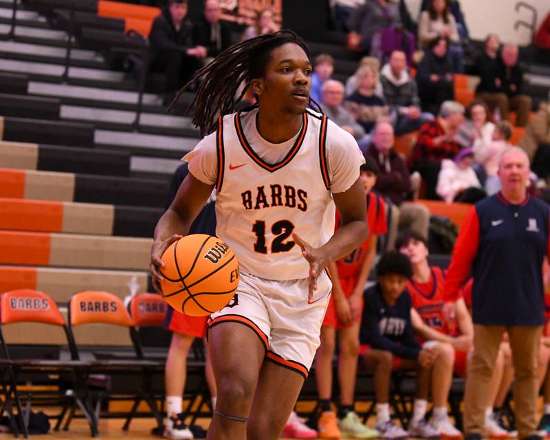 eKalb's Derrion Straughter (12) looks for an open teammate during the game on Friday Dec. 27, 2024, while taking on Belvidere North during the 97th Chuck Dayton Classic Basketball tournament held in DeKalb.
