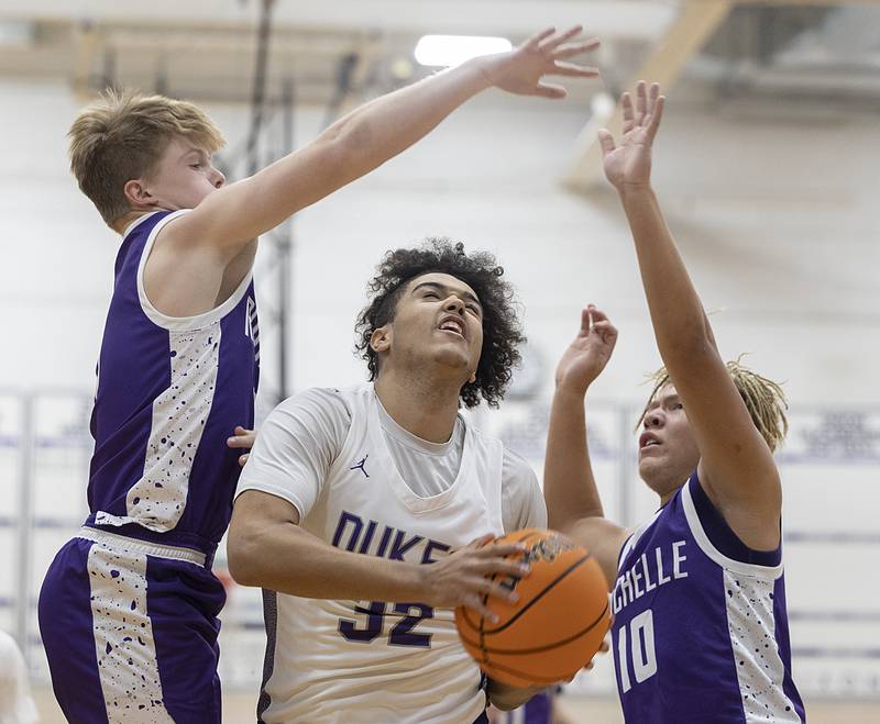Dixon’s Darius Harrington works against Rochelle’s Carson Lewis (left) and Elijah Harley on Monday, Dec. 9, 2024, at Dixon High School.