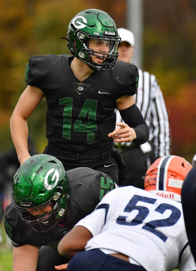 Glenbard West quarterback Charlie Cline (14) calls signals from behind center Luke Leach during an IHSA Class 8A playoff game against Naperville North on Oct. 28, 2023 at Glenbard West High School in Glen Ellyn.