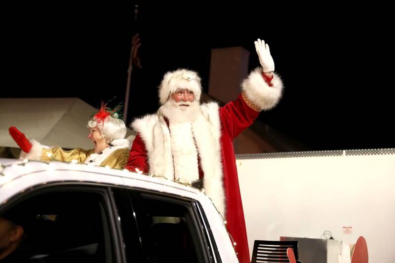Santa and Mrs. Claus wave to the crowd lined up along Front Street during the Wheaton Christmas Parade in downtown Wheaton on Friday, Nov. 25, 2022.