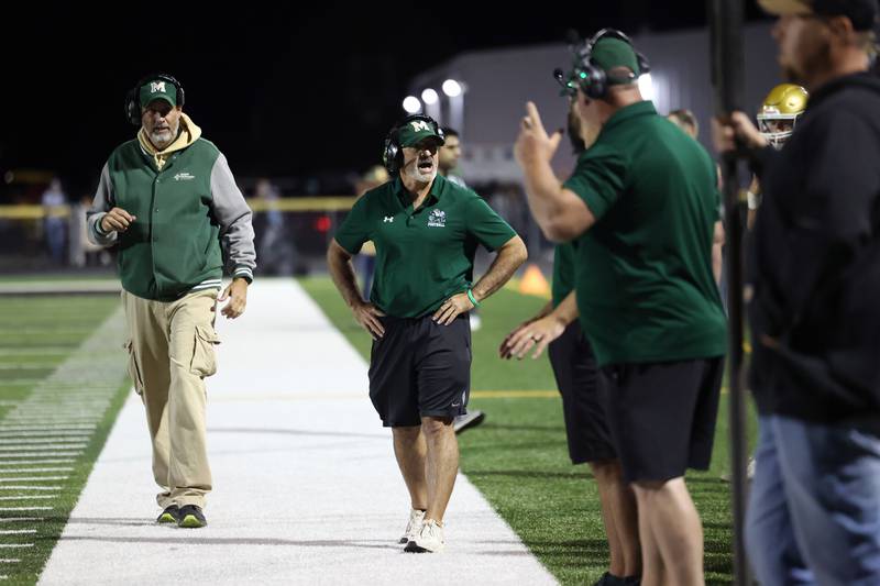 Bishop McNamara head coach Greg Youngblood communicates with fellow coaches during the Fightin' Irish's 45-28 victory over Herscher on Friday, Sept. 5, 2025.