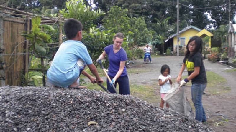 Elizabeth Jilek, a DeKalb native and junior at Lewis University, works with children in Bacolod City, Philippines, last January as part of a mission trip coordinated by the university and Diocese of Joliet. Jilek is hoping to go back this January with the group to build a home for a needy family.