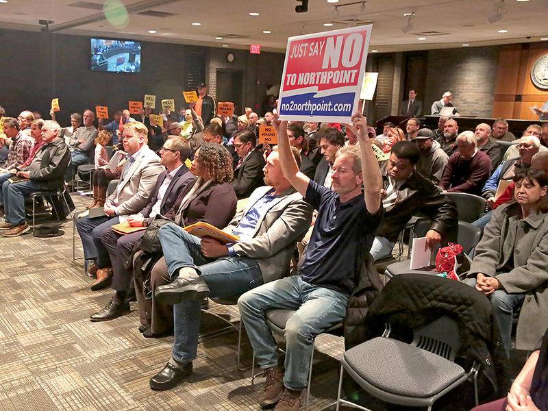 Ron Adams from Manhattan (center) holds a sign opposing NorthPoint on Tuesday, Nov. 19, 2019, at at Joliet City Hall in Joliet, Ill.