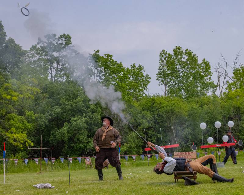 An actor in the Buffalo Bill's Wild West Extravaganza show shoots a balloon out of the air with a backwards trick shot during Wild Bill Days on May 31, 2025 at Jamie's Outpost in Utica.