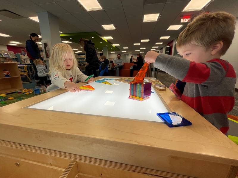 Two-year-old Algonquin resident Andrew Seletos and 3-year-old Mundelein resident Ehvie Reinhart play at a new light-up magnetic table at the Algonquin Area Public Library's Eastgate Branch, which reopened Jan. 6, 2025, after a renovation.