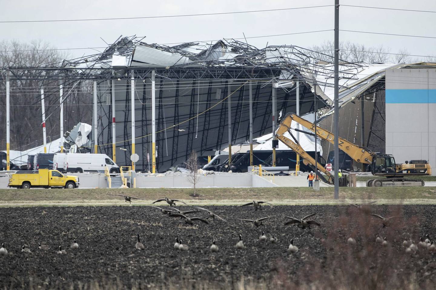 Crews move in heavy equipment for search and rescue operations at the Amazon distribution center in Edwardsville on Saturday, Dec. 11, 2021. Severe storms caused the building to partially collapse with confirmed fatalities. The roof of the building was ripped off, and a wall about the length of a football field collapsed.