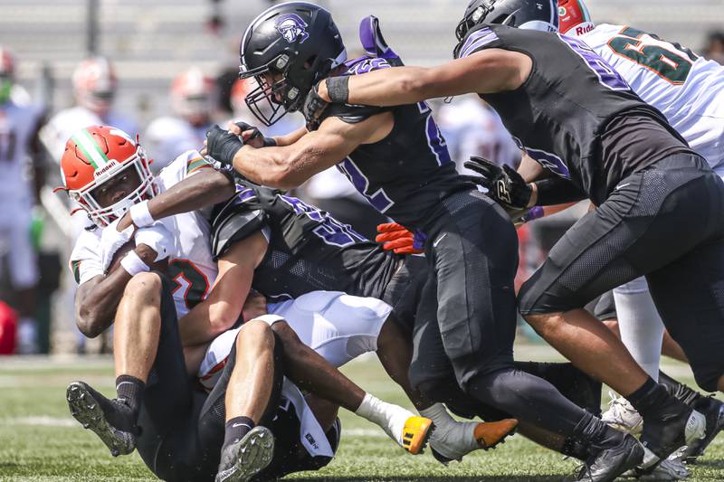 The Downers Grove North's defense swarms Morgan Park's Reggie Gray Jr (2) during football game between Downers Grove North at Morgan Park Saturday, Aug 30, 2025  in Chicago.