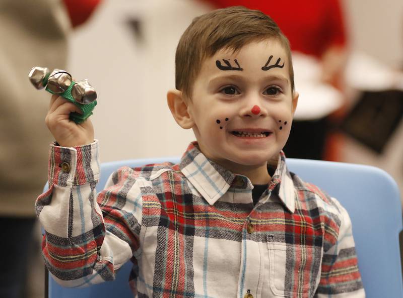 Ryder Stanley, 3, of Huntley, rings bells to the music of Andy Huber on Friday, Dec. 2, 2022, during the Very Merry Huntley Holiday Open House at the Huntley Area Public Library. The event featured musical entertainment by Andy Huber, reindeer, Santa, a scavenger hunt, face painting, and a snowball toss.
