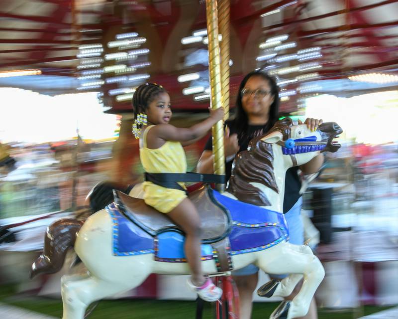 Shaliece Williams, 3 years-old, and mom Sparkle Pryor of North Aurora enjoy the merry-go-round Friday June 17, 2022 during PrairieFest in Oswego.