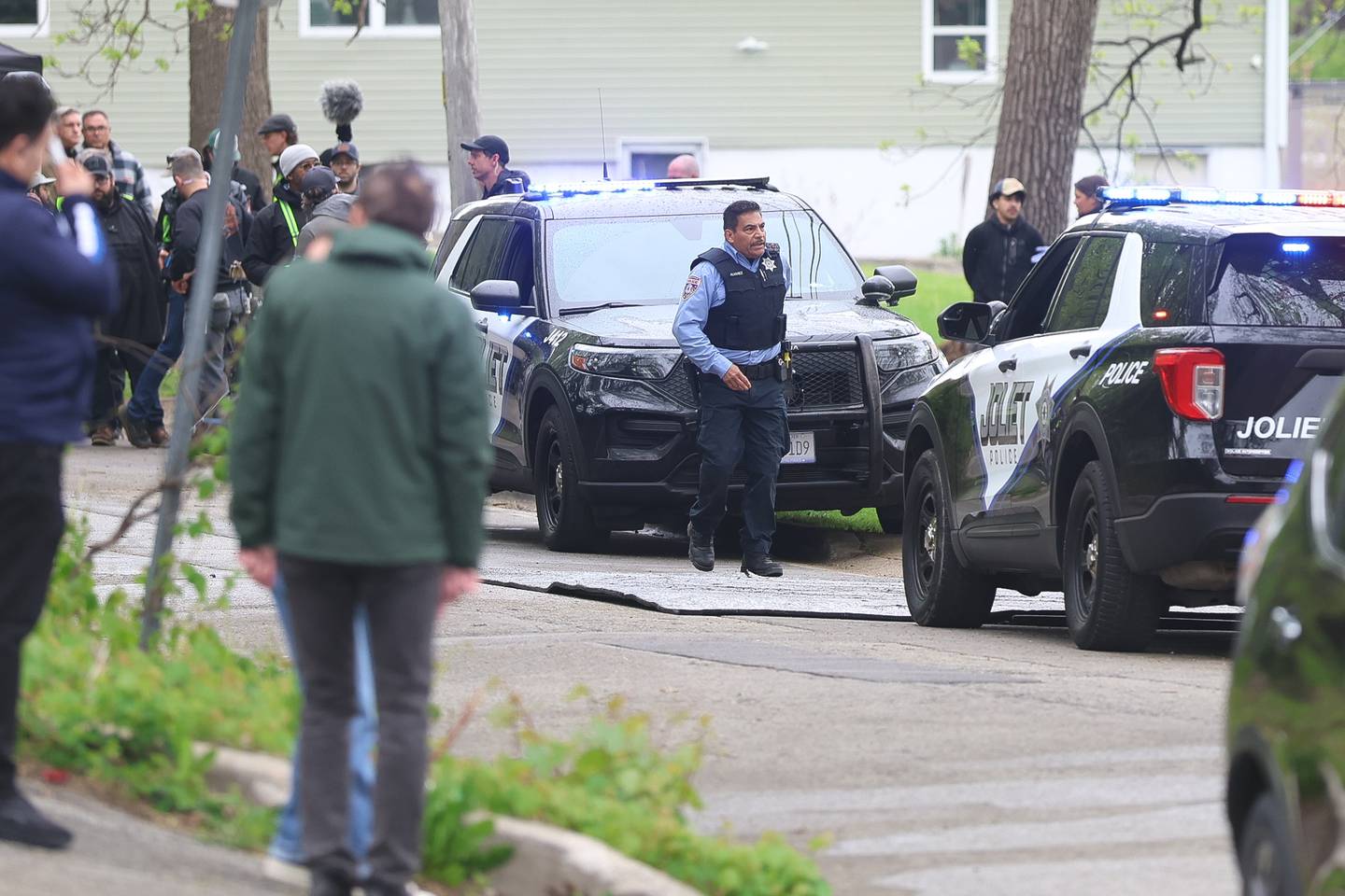 An actor dressed as a Joliet police officer walks along the 500 block of North Bluff street between filming on Monday, April 27, 2026 in Joliet. HBO began filming the pilot for “American Blue” that follows a police chief retuning to Joliet to take over the police department.