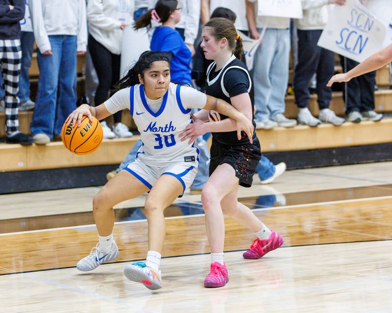 St. Charles North's Lelanie Posada drives the baseline past St. Charles East's Kathlyn Bainbridge on Jan. 30, 2026 in St. Charles.