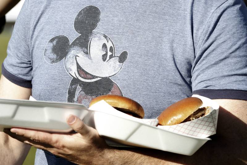 A t-shirt Mickey Mouse stares at Nick Gall’s arm full of barbecue sandwiches from Smiley’s Barbecue during the Algonquin Founders’ Days Festival Friday, july 29, 2022, at Ted Spella Community Park, 2610 Harnish Drive, in Algonquin. This year marks the festival’s 60th anniversary that includes over 40 events, including live music, food and drinks, a carnival, and market bazaar. The festival runs from 2 to 11 p.m. July 30 and 10 a.m. to 9 p.m. July 31. A Founders’ Day Christmas in July Parade will run through Main Street in downtown Algonquin beginning at 11 a.m. July 30.