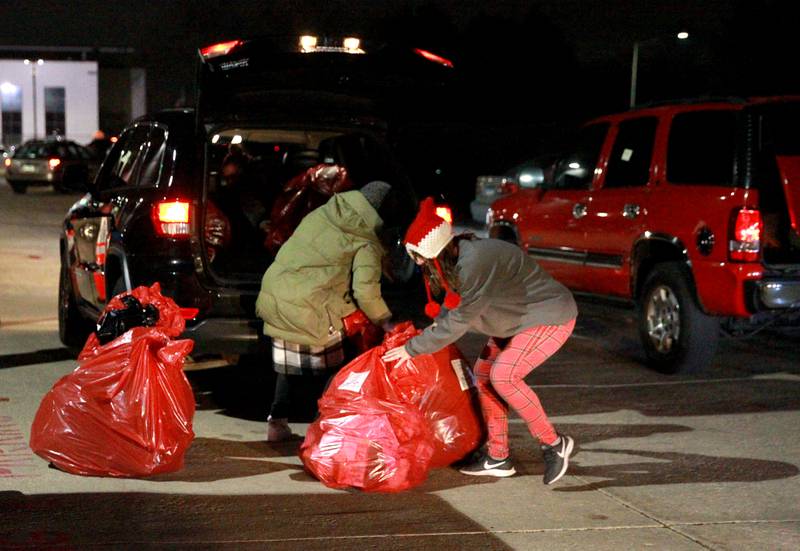 Volunteers load bags of gifts for a family in St. Charles School District 303 for the annual Big Hearts of Fox Valley Christmas Gift Sponsorship Program on Tuesday, Dec. 3, 2024.