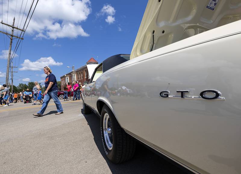 Car enthusiasts pass by hot rods of days gone by Sunday, August 27, 2023 during the Depot Days car show in Amboy.