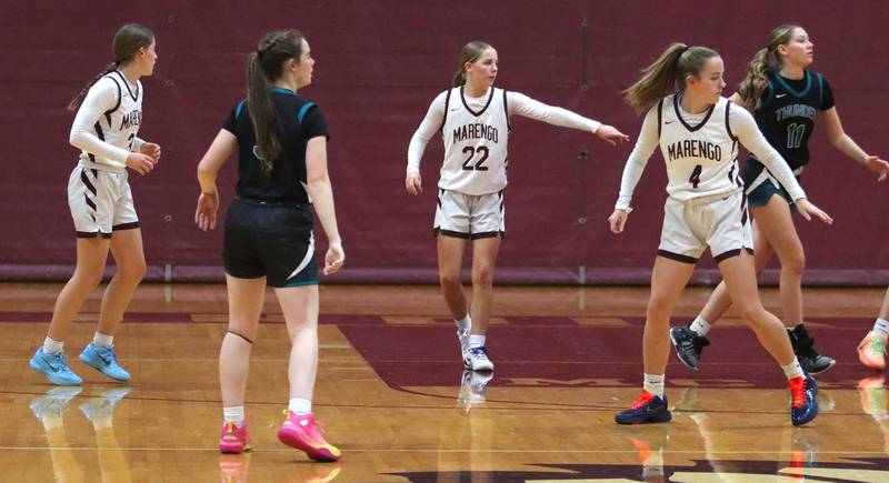 Marengo’s Hansons, from left, Maggie, Sophie and Katie play defense against Woodstock North in varsity girls basketball on Tuesday, Dec. 2, 2025, at Marengo High School in Marengo.