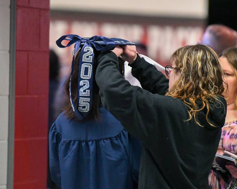 An Oswego East graduate gets some assistance with her cap before making her way to line up for the commencement ceremony on Saturday May 17, 2025, held at the Convocation Center in DeKalb.