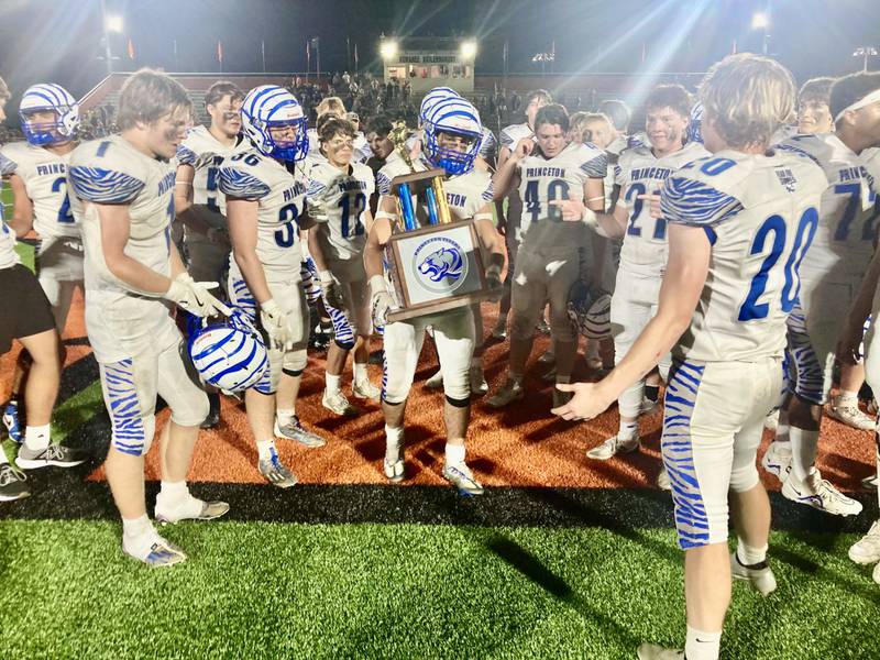 Princeton senior captain Ace Christiansen carries the traveling trophy after the Tigers defeated longtime rival Kewanee 44-15 Friday night The Tigers now lead the all-time series 65-57-4.
