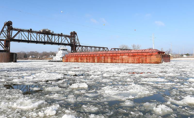 An American River Transportation Company (ARTCO) tugboat pushes a barge through the icy waters of the Illinois River on Jan. 13, 2022 near Ottawa. As temperatures rise above freezing the ice begins to melt and disperse throughout the Illinois River.