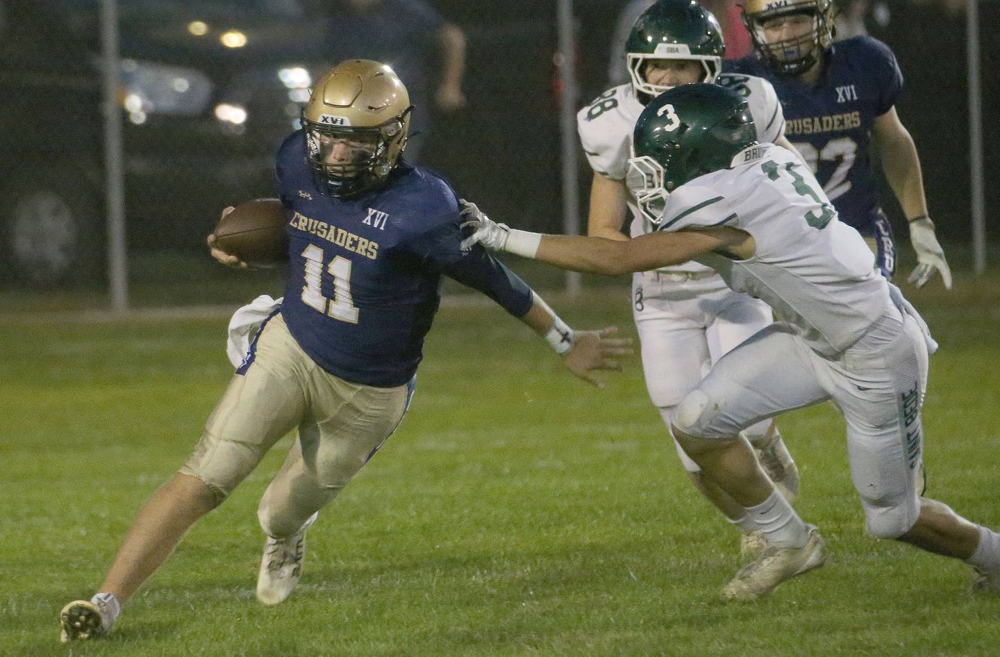 Marquette quarterback Anthony Couch gets around St. Bede players Stuart McGunnigal and Brody Burris during a run on Friday, Sept. 26, 2025 at Gould Stadium in Ottawa.