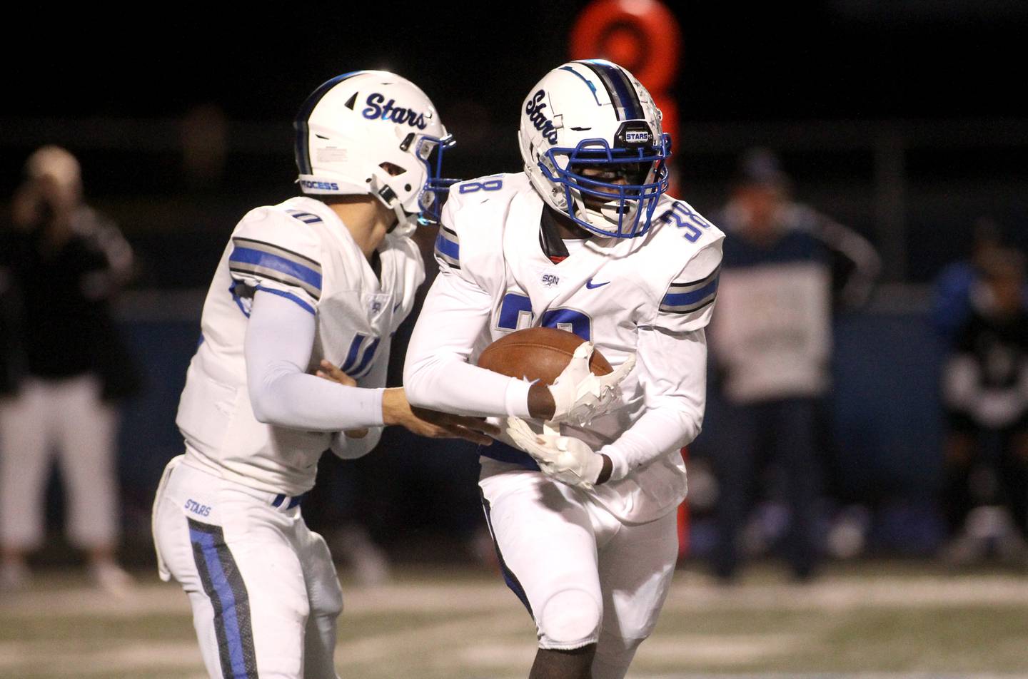 St. Charles North quarterback Ethan Plumb hands the ball off to Joell Holloman during a game at Geneva on Friday, Sept. 23, 2022.