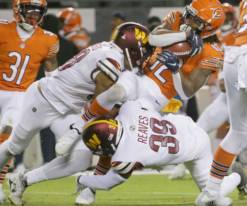 Chicago Bears Wide Receiver Velus Jones Jr. (12) is brought down by Washington Commanders Armani Rogers (88) and teammate Jeremy Reaves (39) on Thursday, Oct. 13, 2022 at Soldier Field.