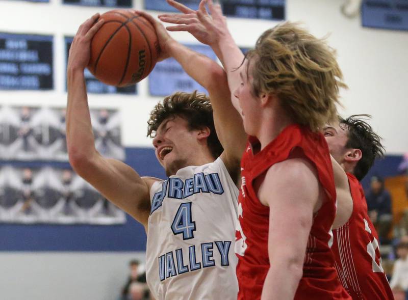 Bureau Valley's Landon Hulsing grabs a rebound over Hall's Wyatt West and Braden Curran on Friday, Jan. 19, 2024 at Bureau Valley High School.