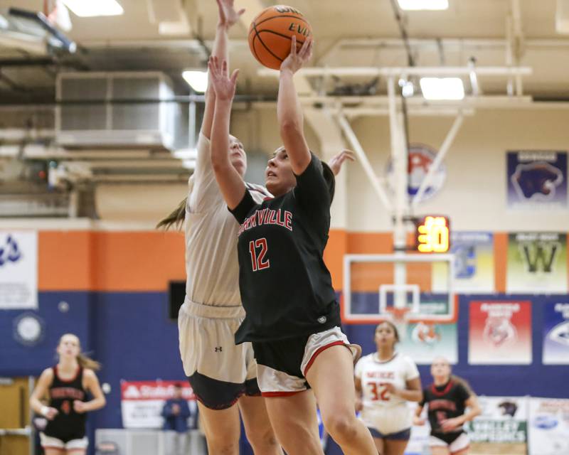 Yorkville's Hayden Hodges (12) puts up a shot over Oswego's Kendall Grant (42) during their basketball game between Yorkville at Oswego, Feb 7, 2026 in Oswego.