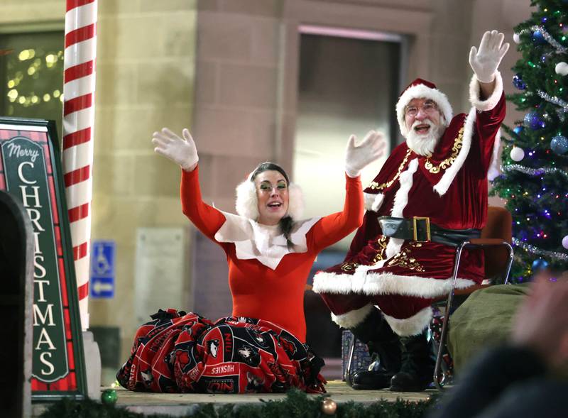 Santa Claus and his helper Elfie wave to kids as they make their way down Lincoln Highway Thursday, Dec. 4, 2025, during the annual Lights on Lincoln and Santa Comes to Town event hosted by the DeKalb Chamber of Commerce.