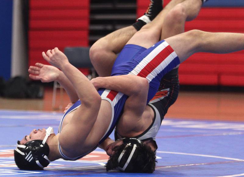 McHenry’s Aiden Fischler, right, and Dundee-Crown’s Jose Gavina come in for a landing as they battle at 160 pounds in varsity wrestling at Carpentersville Thursday night.