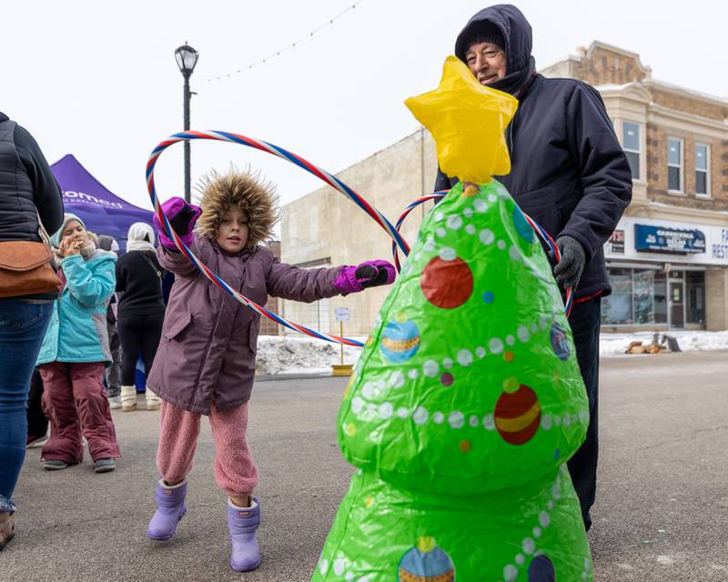 Madeline Prescott throws hula-hoop onto Christmas Tree on Saturday, December 6, 2025 on Illinois Avenue in Mendota.