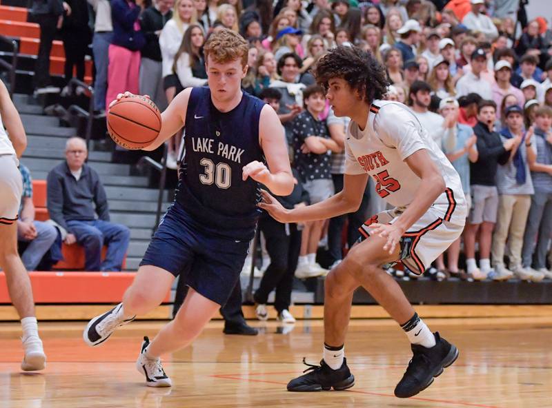 Lake Park's Thomas Rochford (30) drives around Wheaton Warrenville South's Braylen Meredith (25) during a game on Saturday, Jan. 7, 2023.
