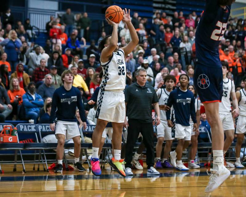 Oswego East's Alton Bullock (32) shoots a three to force the game into overtime during their basketball game between Oswego at Oswego East, Feb 13, 2026 in Oswego.