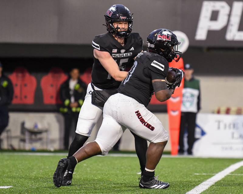 Northern Illinois University's quarterback Josh Holst (15) hands the ball off to teammate  running back Chavon Wright (10) during the game on Saturday Oct. 25, 2025, held at Huskie Stadium in DeKalb.