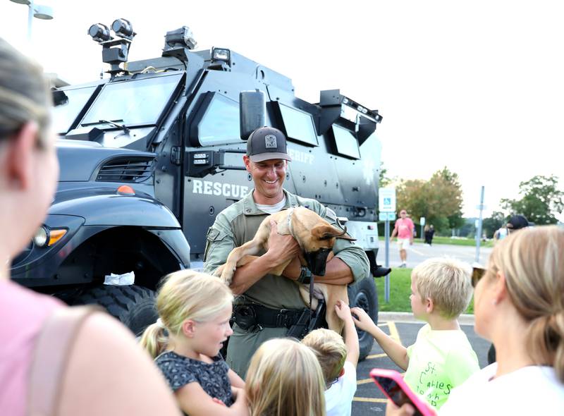Kane County Sgt. Nick Wolf holds Ike, a 15-week-old Malinois puppy during the Kane County Sheriff’s Office National Night Out event in St. Charles on Tuesday, Aug. 1, 2023. The community-building event began nationally in 1984. Wolf is training the puppy, who will eventually work as a K-9 officer.