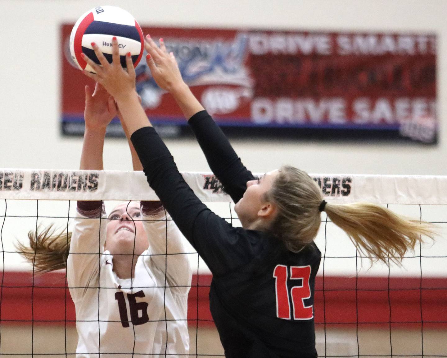 Prairie Ridge’s Addy Grider, left, battles  Huntley’s Summer Massow in varsity girls volleyball at Huntley High School in Huntley on Thursday, Sept. 11, 2025.