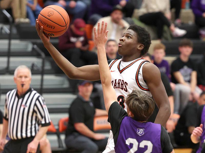 DeKalb’s Davon Grant goes by Dixon’s Bryce Feit to the basket during their game Tuesday, Dec. 12, 2023, at DeKalb High School.