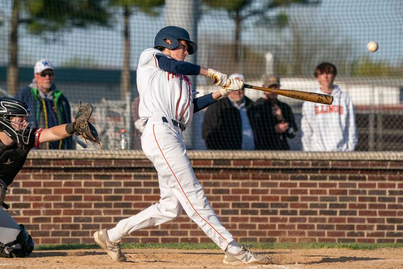 Oswego’s Luke Voelker (19) drives the ball to the outfield against Minooka during a baseball game at Oswego High School on Tuesday, April 18, 2023.