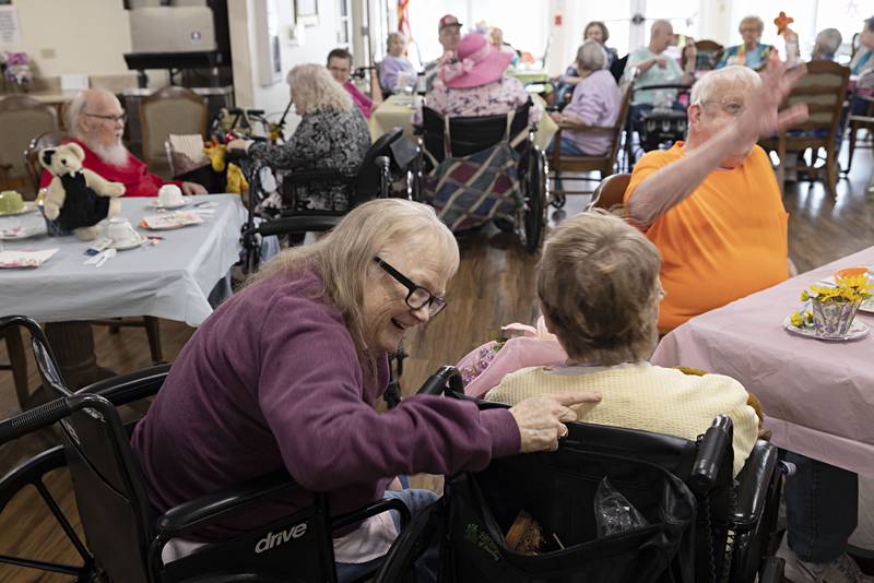 Cherri Smith shares some words with her friend and tea party honoree Margie Mathias Friday, March 31, 2023.
